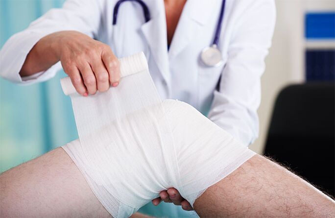 medico che fascia l'articolazione del ginocchio con l'artrosi